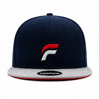 Navy blue snapback hat with red and white embroidered logo, gray brim, and sticker on visor